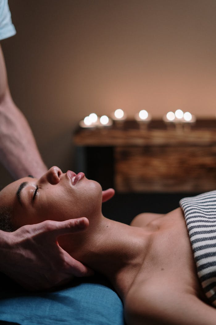 A woman enjoying a relaxing face massage in a tranquil spa setting.